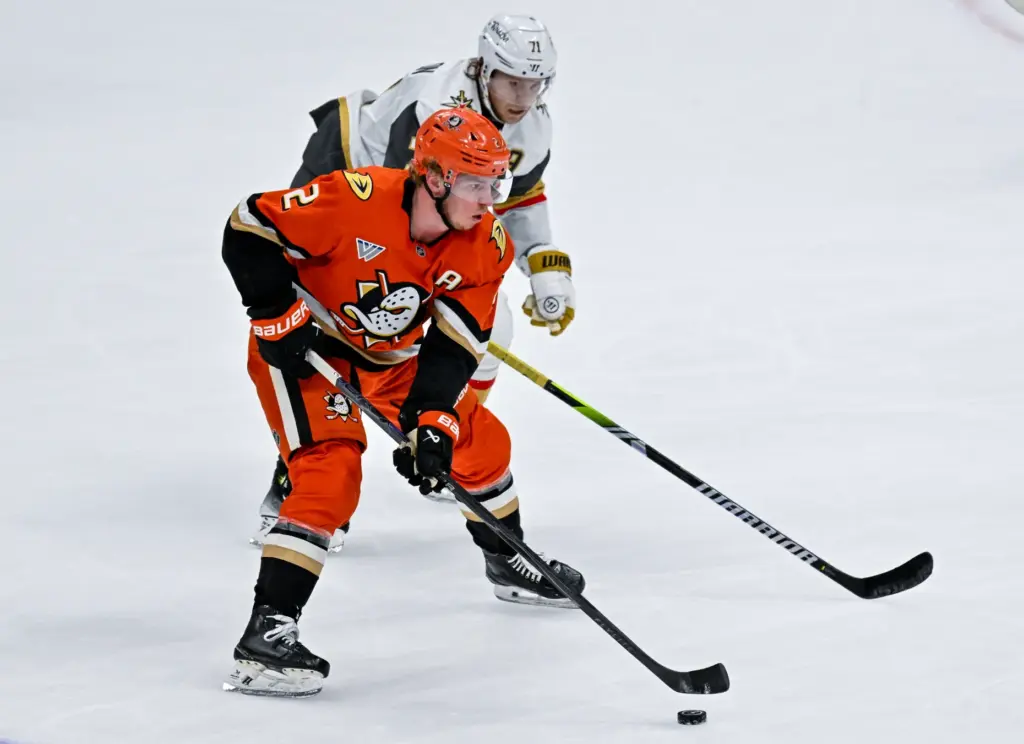 The Ducksâ Jackson LaCombe, front, controls the puck as the...