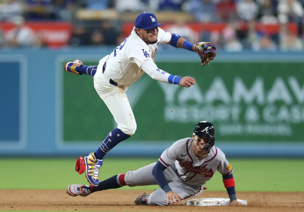 Dodgers shortstop Miguel Rojas throws to first base after avoiding...