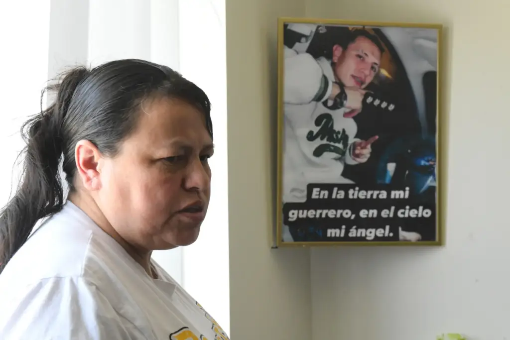 Adriana Garzon, mother of Brayan Rayo Garzon, stands next to a photo of him.