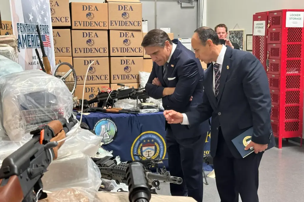 Acting Attorney General Todd Blanche looks at weapons and drugs seized by federal officers.