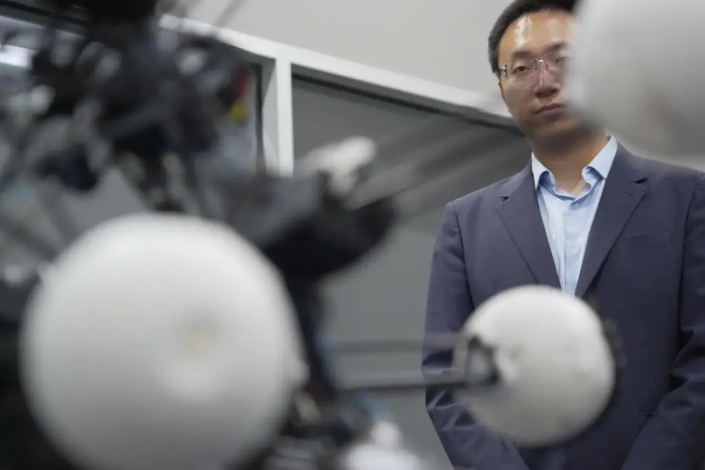 Professor Boyuan Chen watches as a robot named Argus expands...