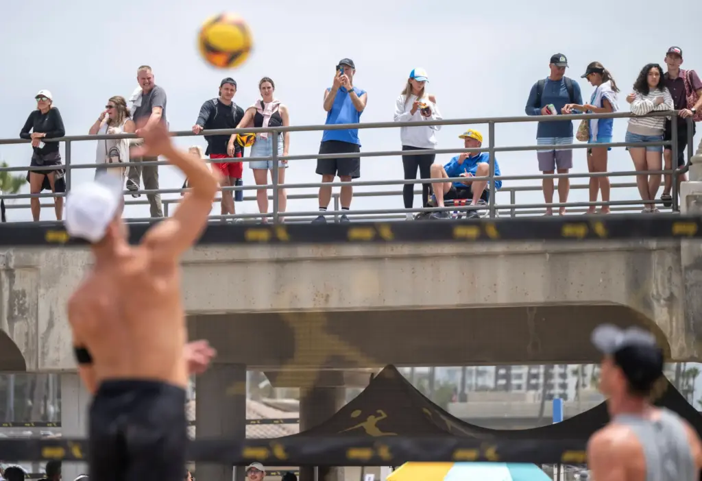 Fans watch volleyball matches from the pier during the AVP...