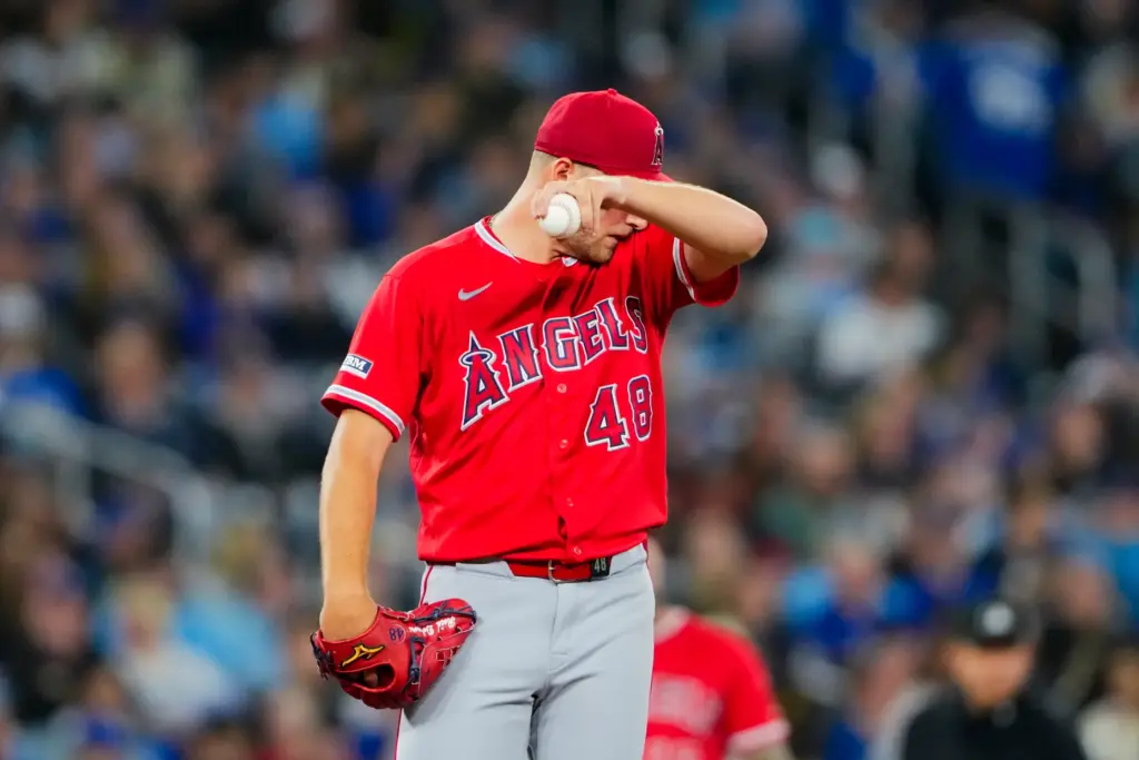 Angels starting pitcher Reid Detmers wipes his face during the...