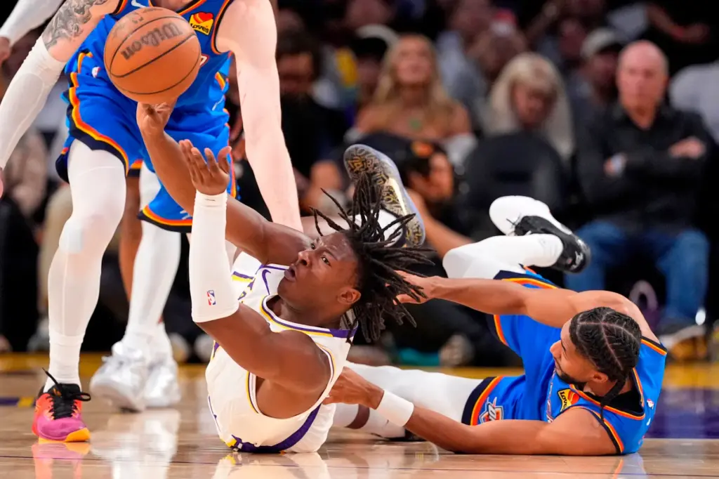 Lakers forward Adou Thiero, left, passes the ball from the...