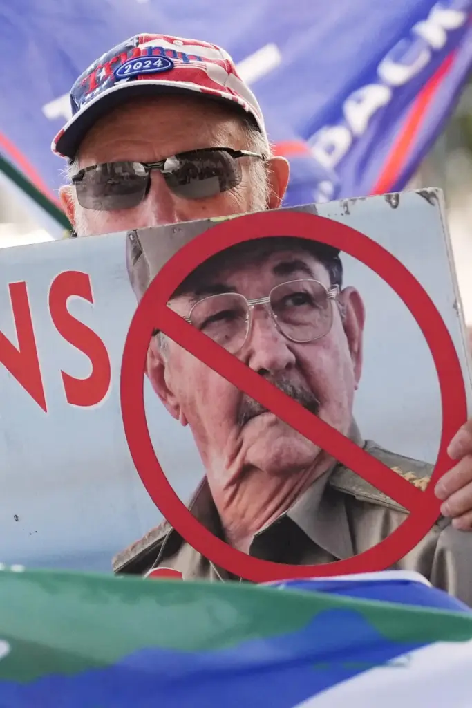 Agustin Acosta holds a placard protesting former Cuban President Raul...