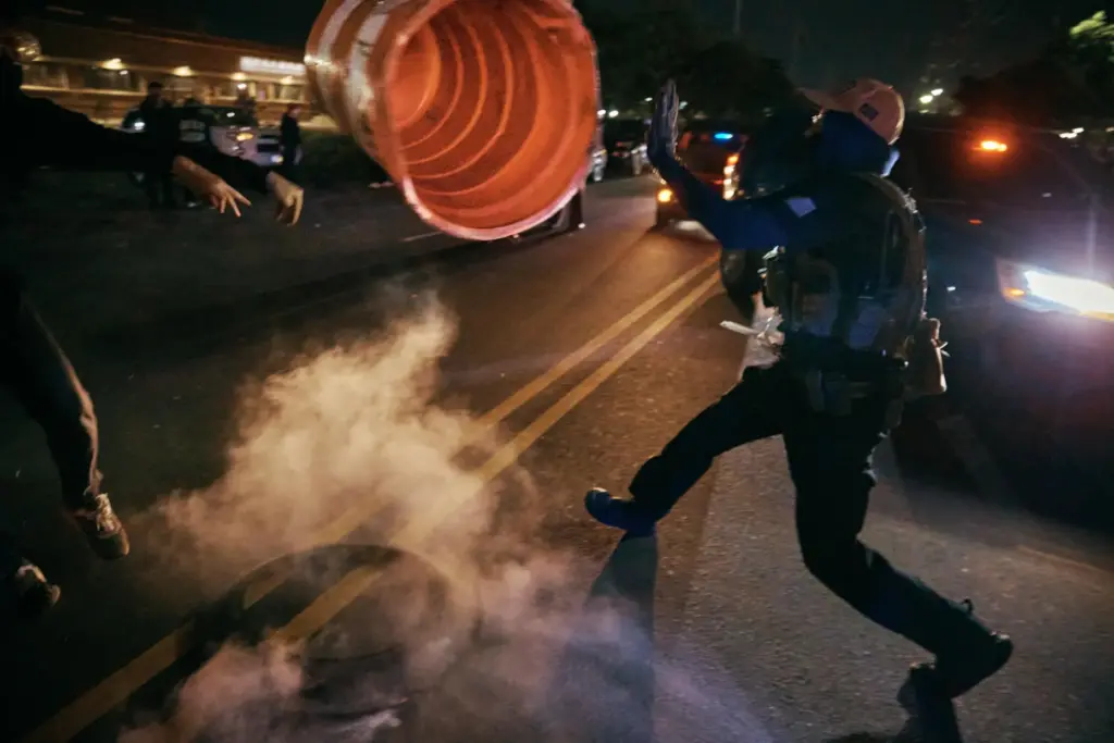 A protester throws a traffic cone to an ICE agent...