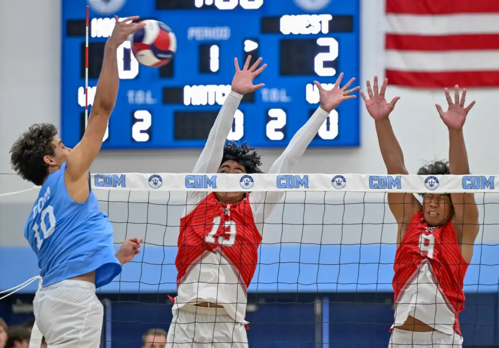 Corona del Mar outside hitter Hunter Hannemann hits the ball...