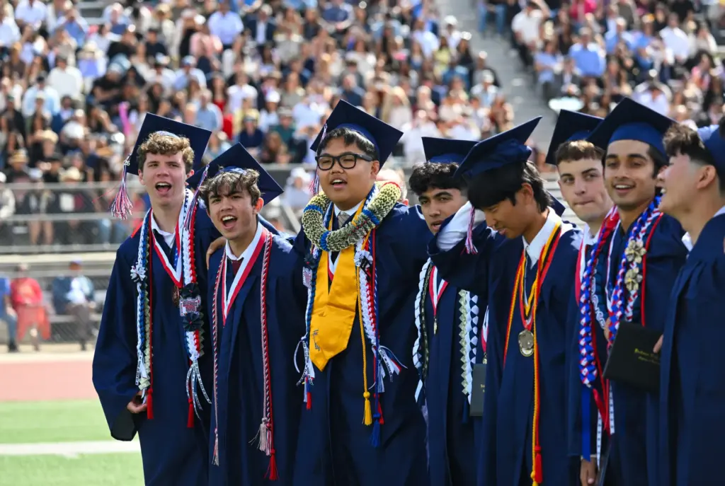 Graduates sing the Beckman High School alma matter during their...