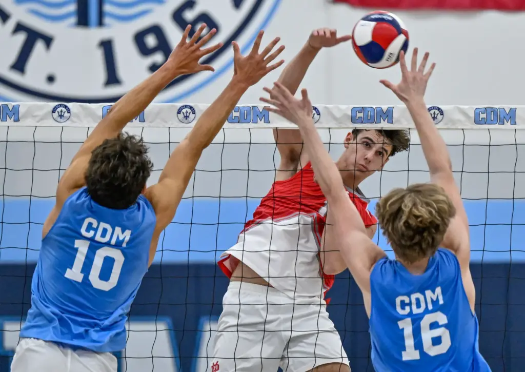 Mater Dei middle blocker Sawyer Stys hits the ball past...