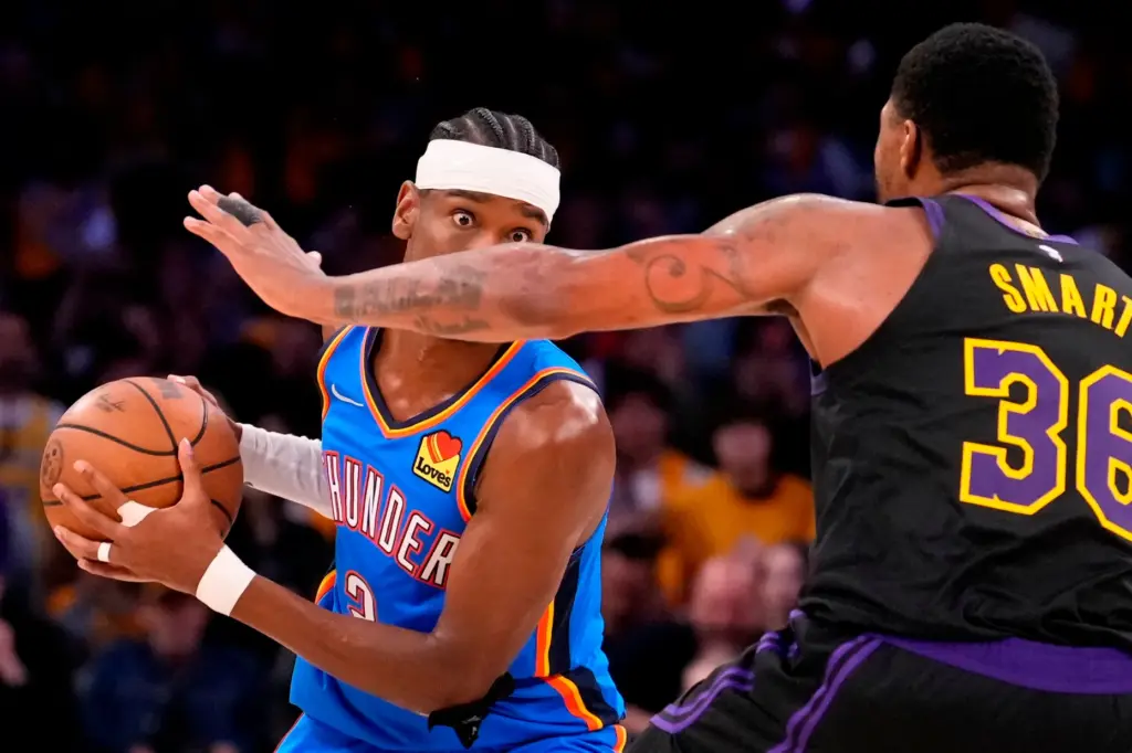 Oklahoma City Thunder guard Shai Gilgeous-Alexander, left, tries to get...