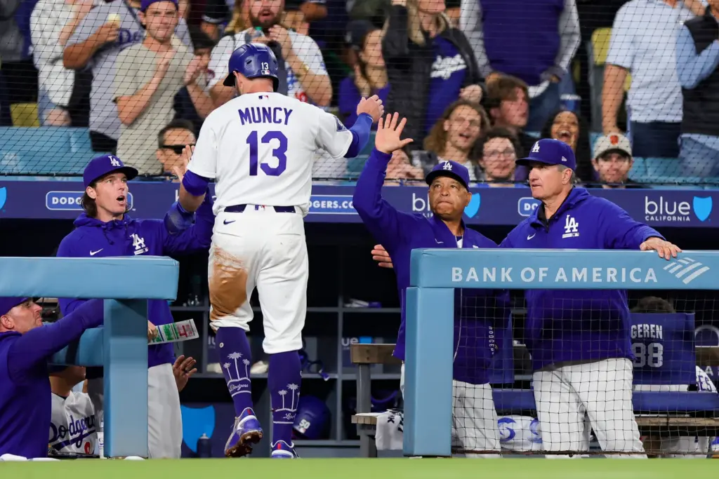 The Dodgers’ Max Muncy (13) is greeted by Manager Dave...