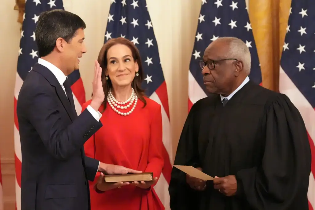 Justice Clarence Thomas, right, administers the oath during the swearing in of Kevin Warsh