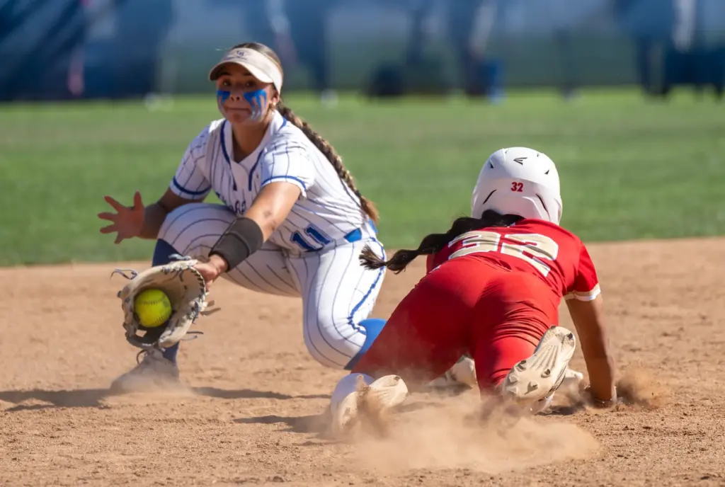 Orange Lutheran shortstop Madelyn Armendariz dives safely back to second...
