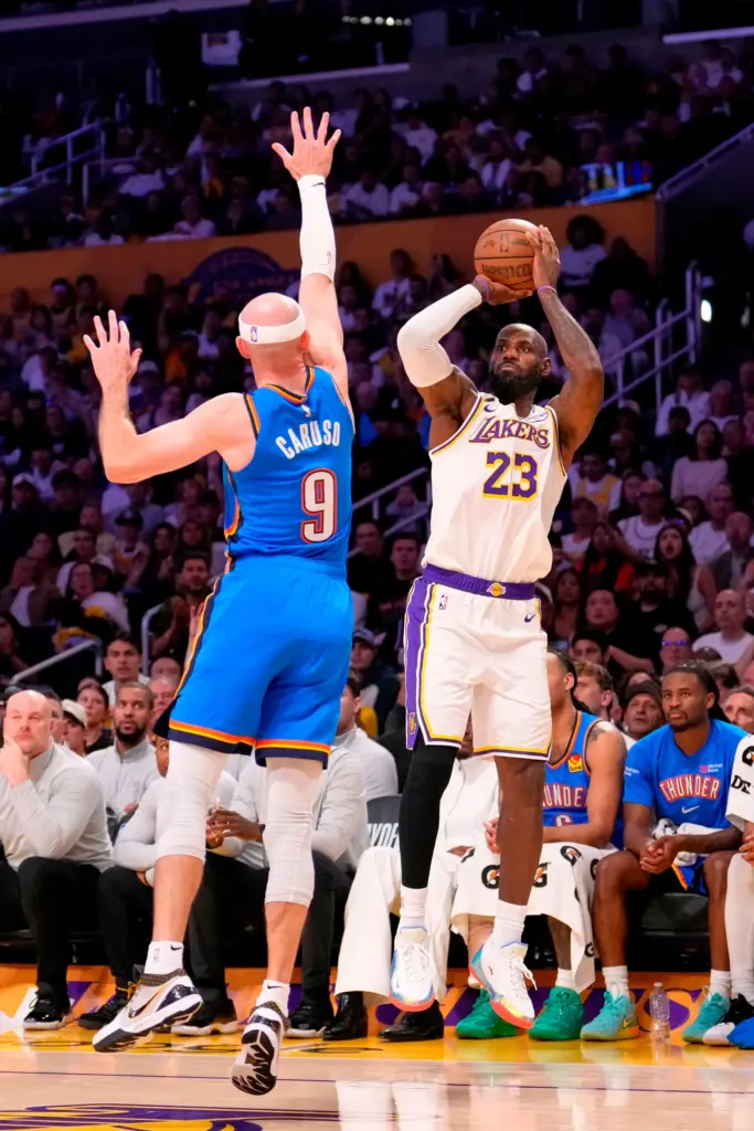 Lakers star LeBron James, right, shoots as Oklahoma City Thunder...