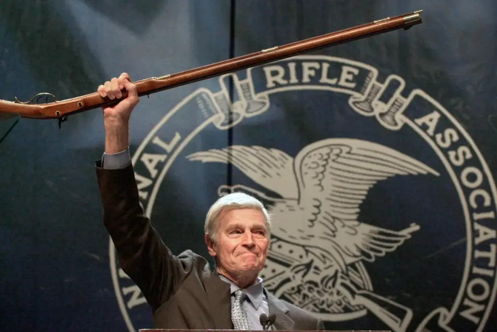 FILE – NRA president Charlton Heston holds up a musket...
