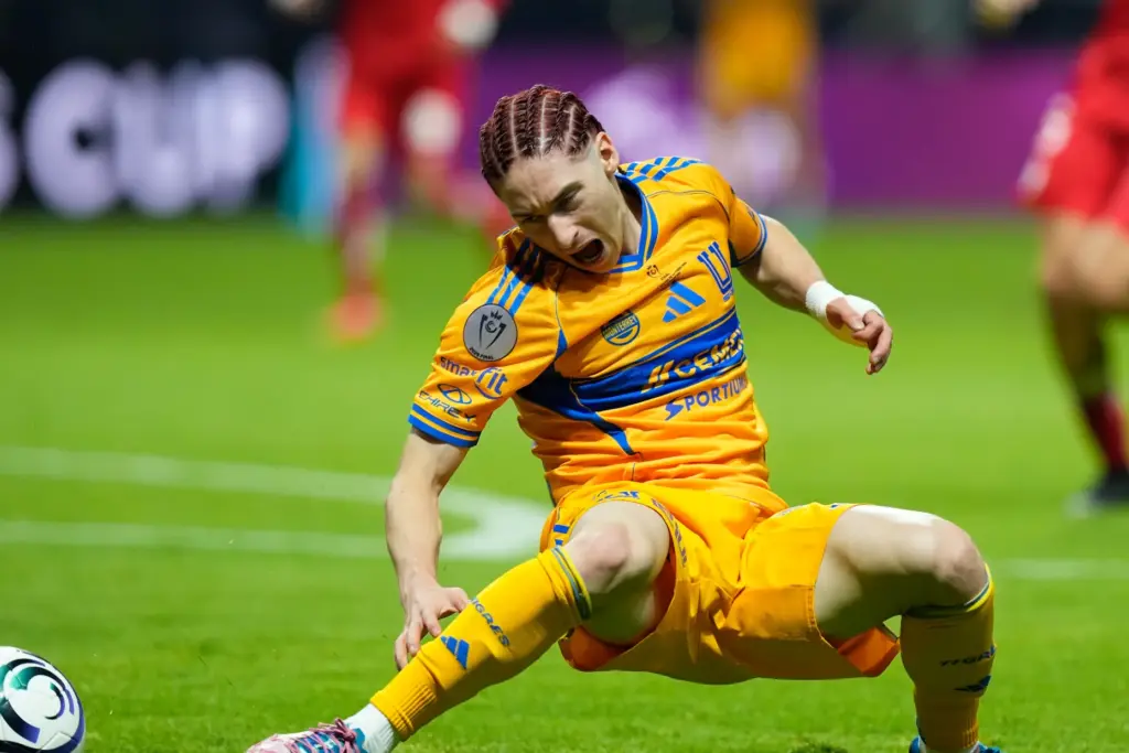 Tigres’ Marcelo Flores gets injured trying to reach the ball...