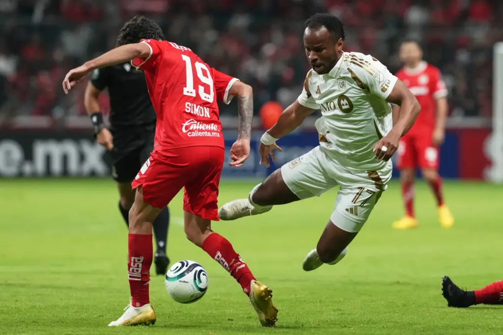 LAFC’s Jeremy Ebobisse, right, and Toluca FC’s Simon Santiago compete...