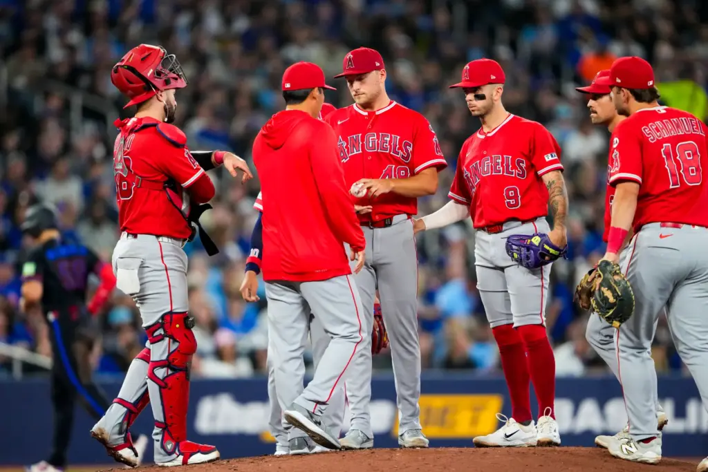 Angels starting pitcher Reid Detmers (48) hands the ball to...