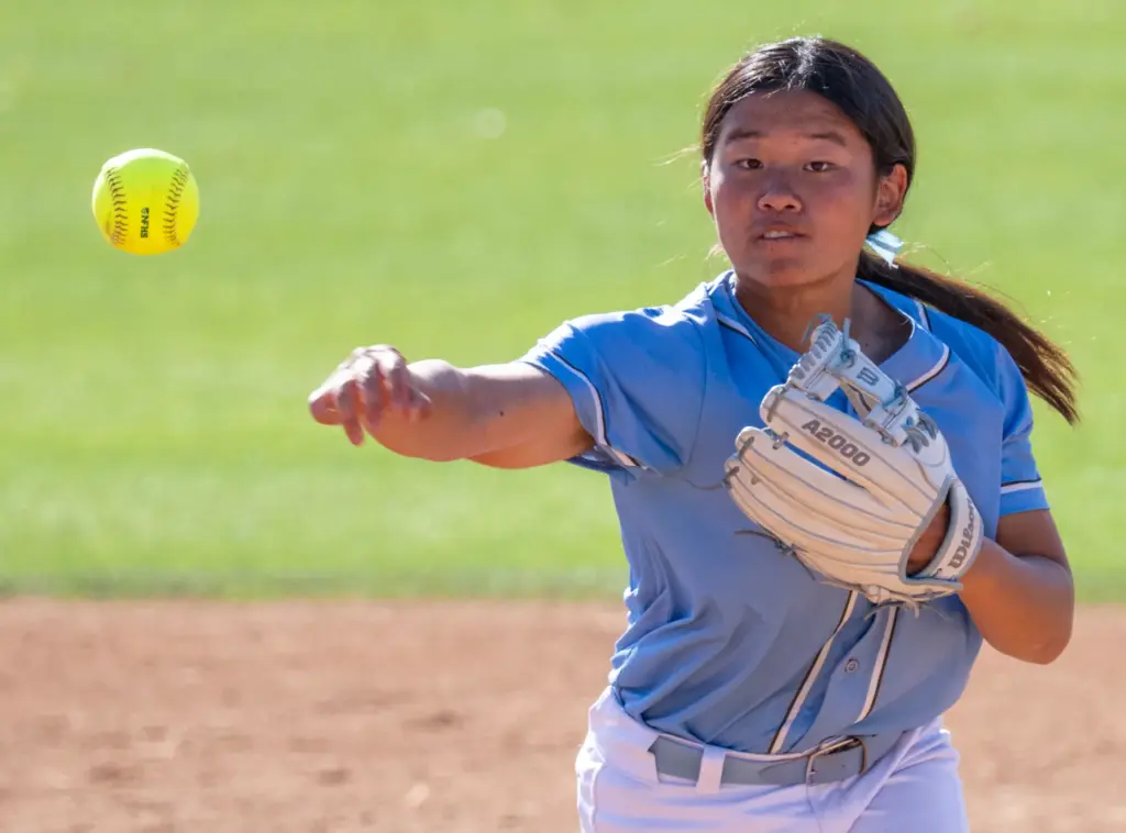 Irvine shortstop Katie Liu throws to first base after fielding...