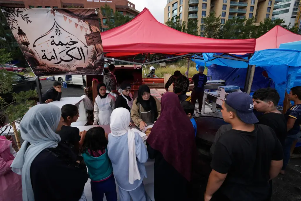 Soubhiye Zeiter speaks with displaced people who lined up to receive mana'eesh.