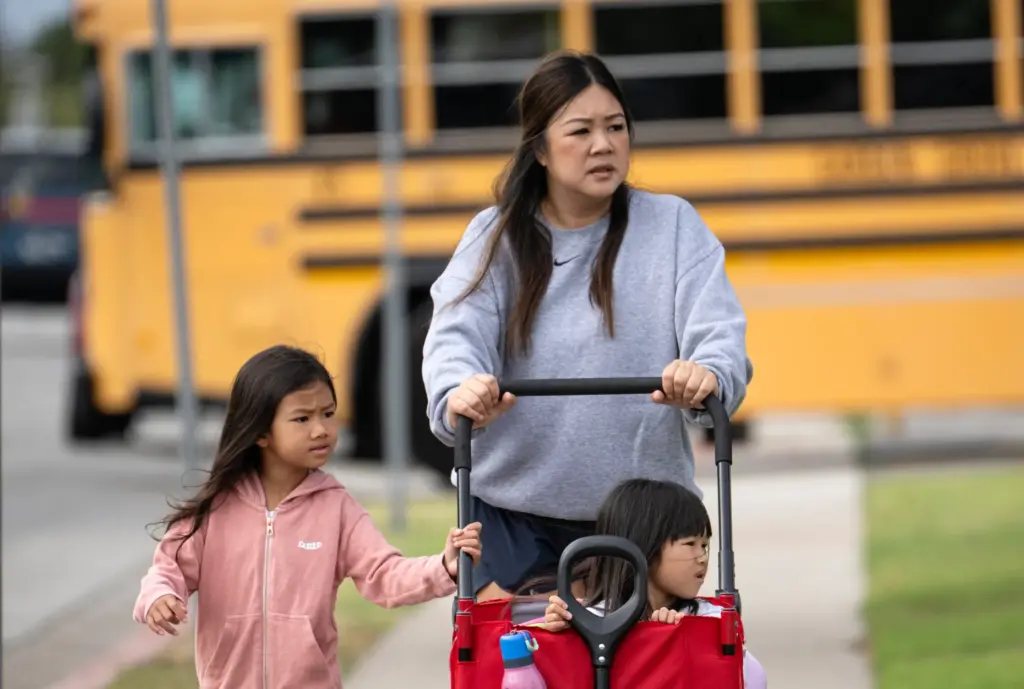 Helen Damâwalks he 6-year-old daughter, Taylor, left,back to school in...