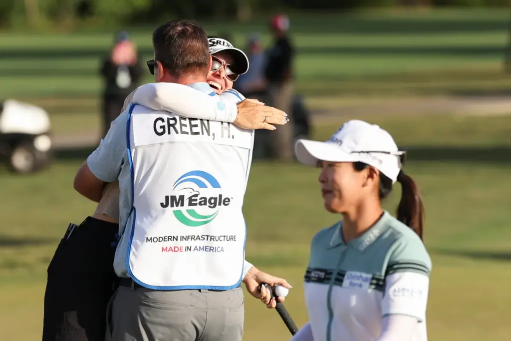 Hannah Green and her caddie David Buhai, back left, embrace...