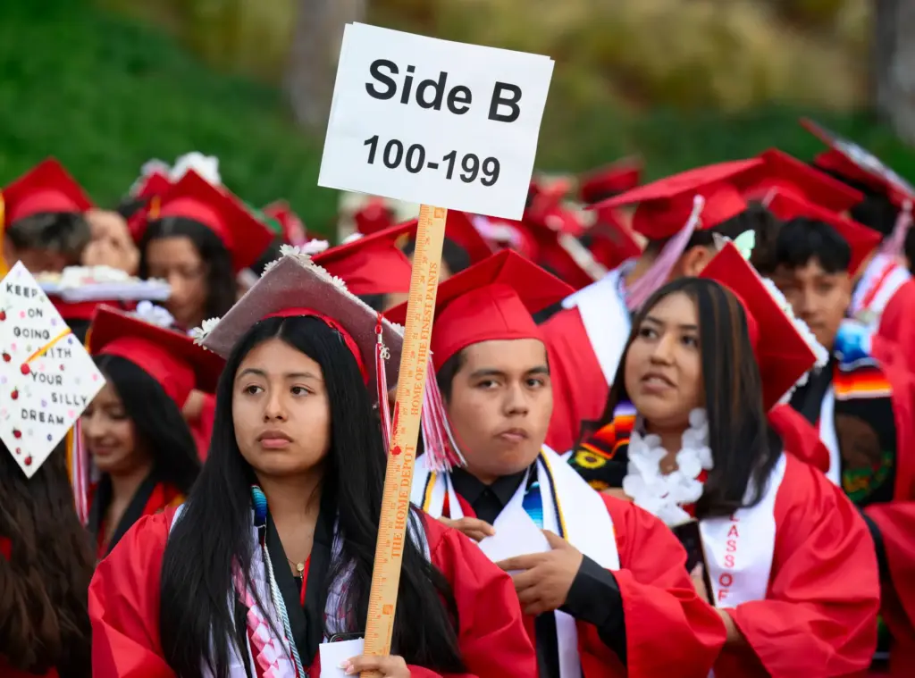 Ashley Flores leads off her section of graduates for the...