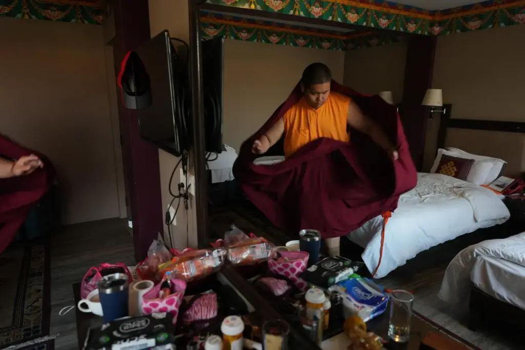 U.S.-born Buddhist lama Jalue Dorje puts on his monastic robes...
