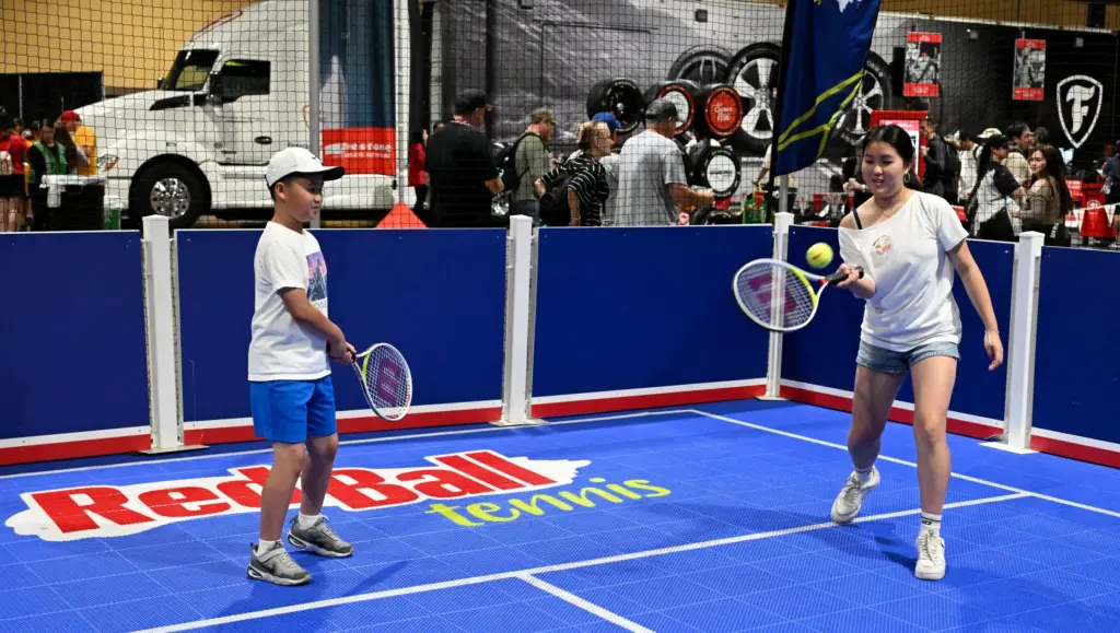 Race fans try out a game of Red Ball Tennis...