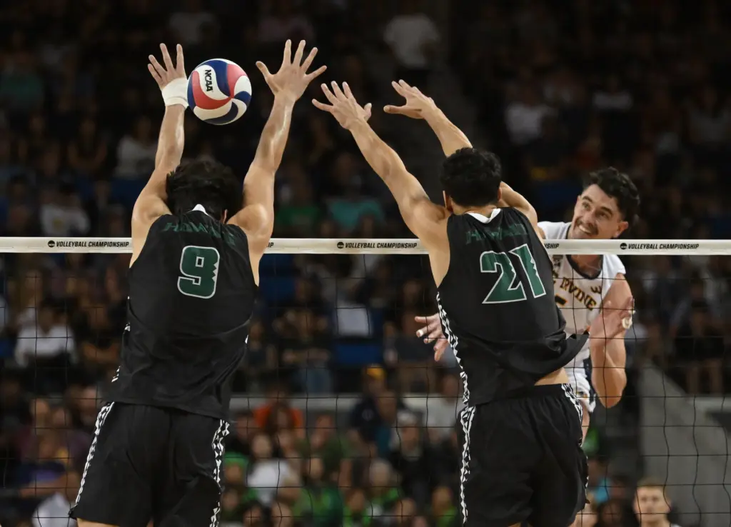 UC Irvineâs William D’Arcy, right, spikes the ball against Hawaiiâs...