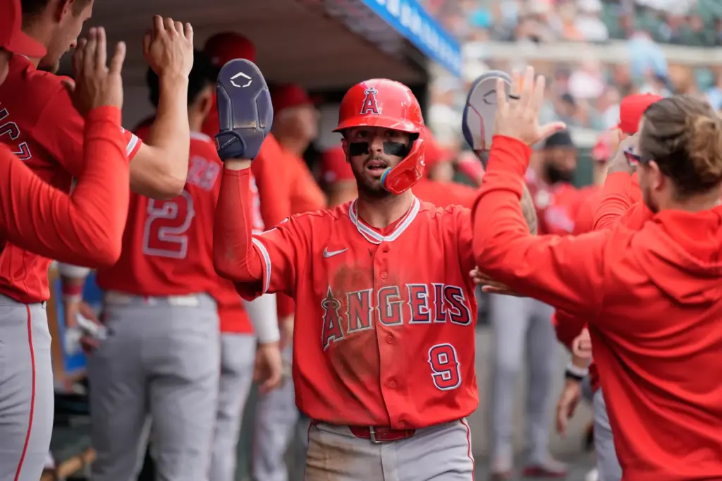The Angels’ Zach Neto celebrates in the dugout after scoring...
