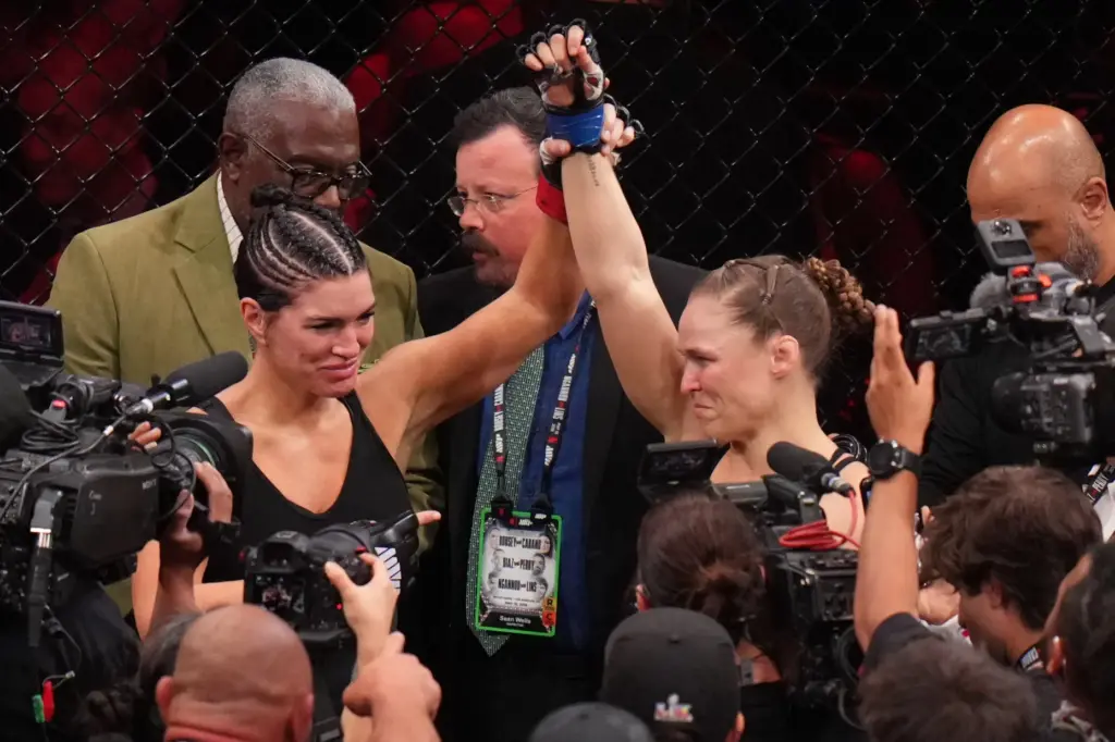 Gina Carano, of the United States, left, lifts the arm...
