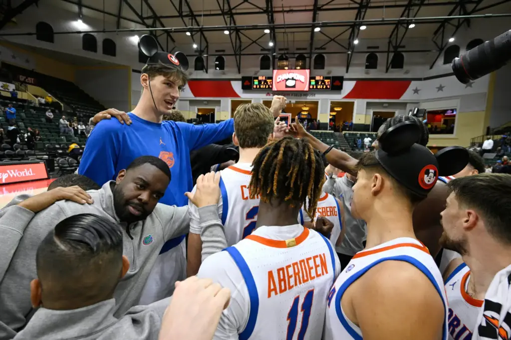 Seven-foot-9 Florida center Olivier Rioux, upper left, huddles with teammates...