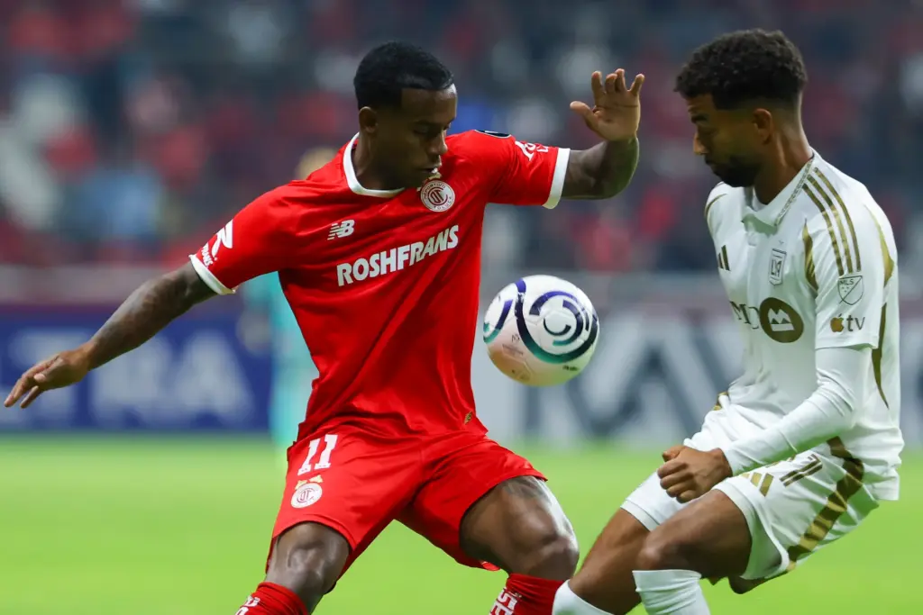 Toluca FC’s Helio Nunes, left, battles for the ball with...