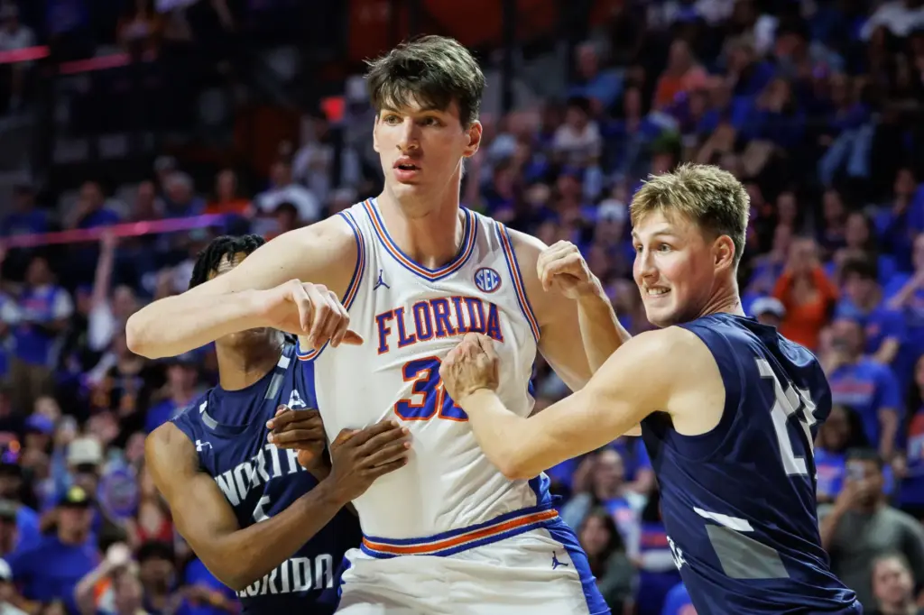 Florida center Olivier Rioux (32) pushes past North Florida forward...