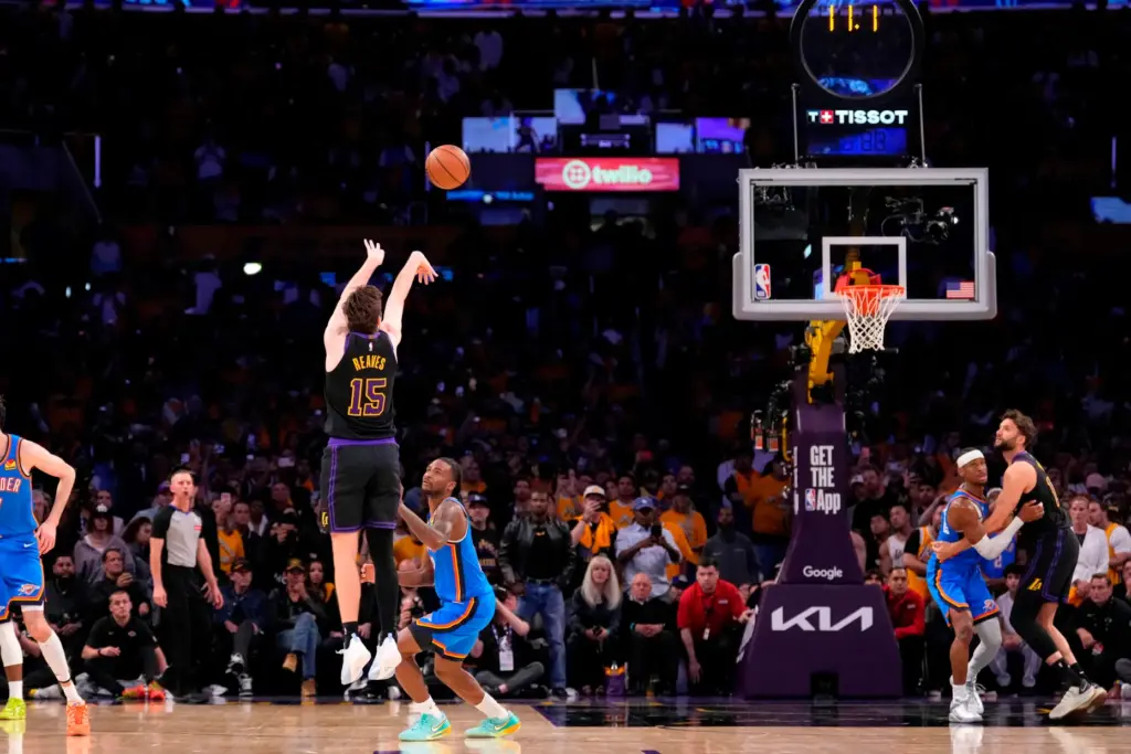 Lakers guard Austin Reaves, left, attempts and misses a 3-point...