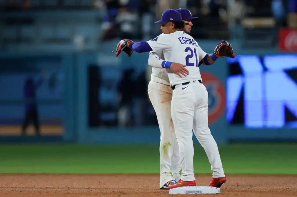 Dodgers shortstop Miguel Rojas, left, greets second baseman Santiago Espinal...