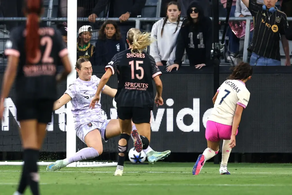 Angel City FC goalkeeper Angelina Anderson, left, deflects a shot...