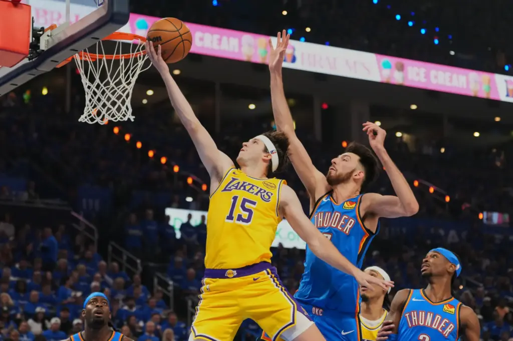 Lakers guard Austin Reaves, left, shoots after getting past Oklahoma...