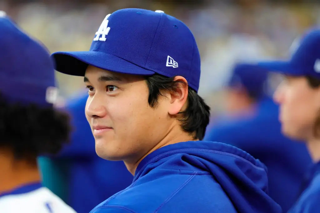 Dodgers star Shohei Ohtani sits in the dugout before a...