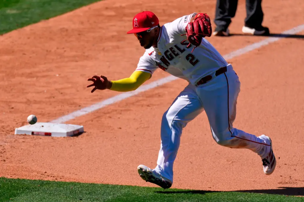 Angels third baseman Oswald Peraza tries to barehand a ball...