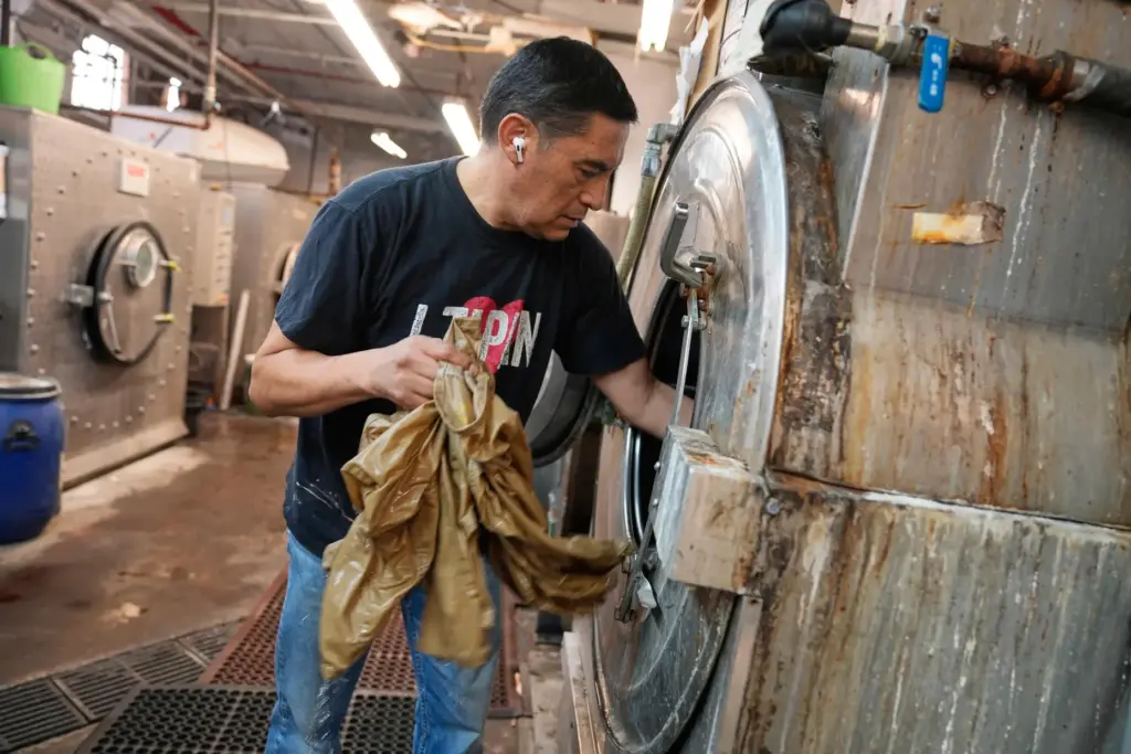 Ruben Revollo inspects some samples after washing them at the...
