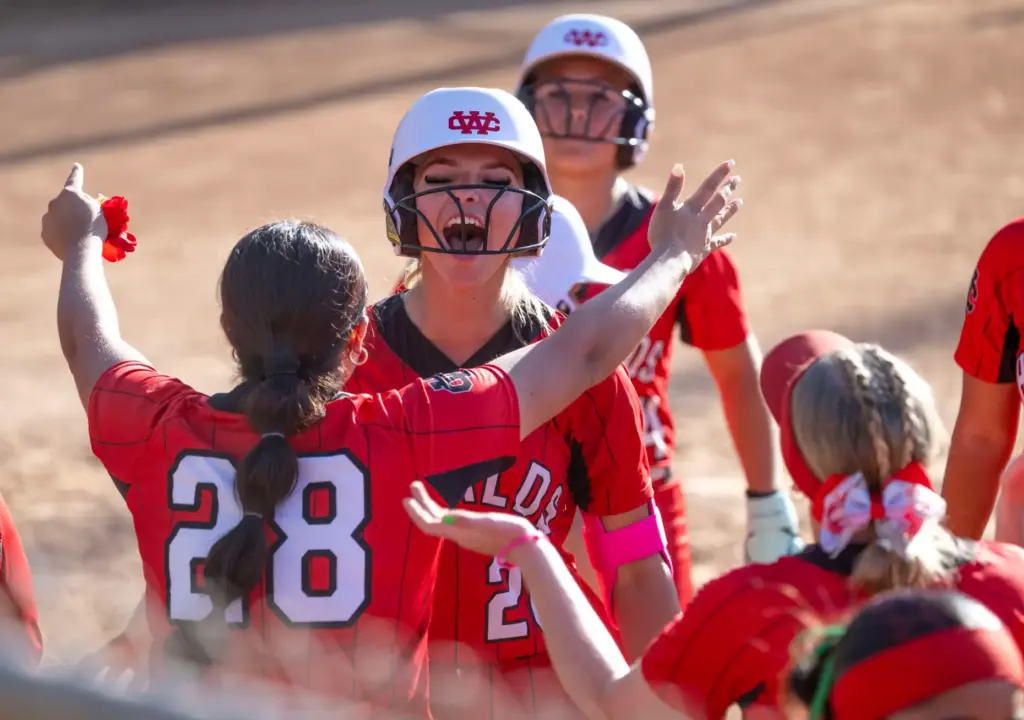 Whittier Christian players celebrate a home run by Bella Perez...