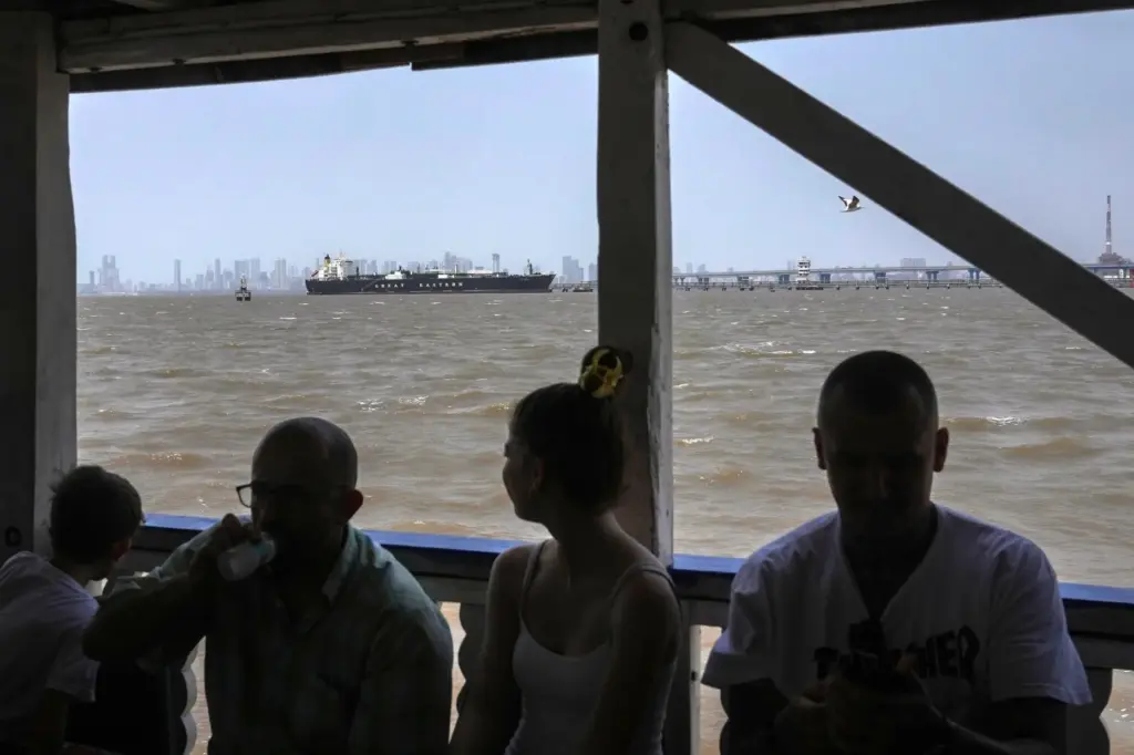 A tourist ferry sails past the Indian-flagged LPG carrier Jag Vasant.