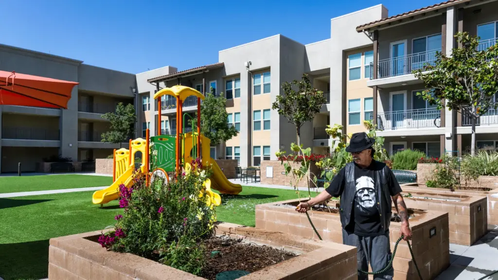 Resident Kevin Weber waters the gardens at Legacy Square in...