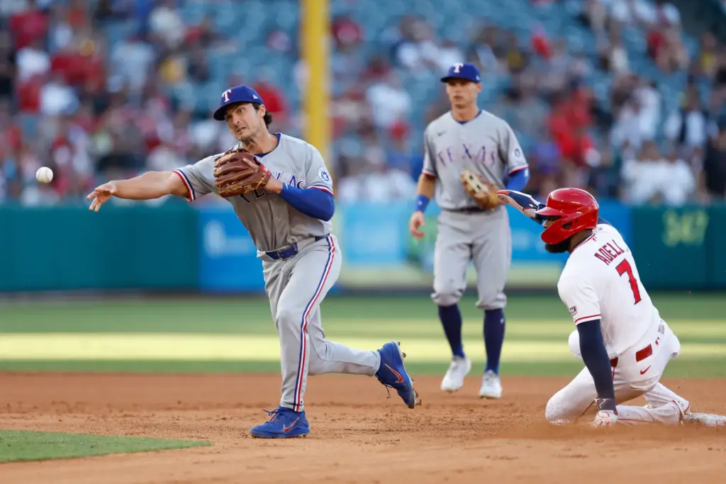 Texas Rangers second baseman Justin Foscue, left, throws to first...