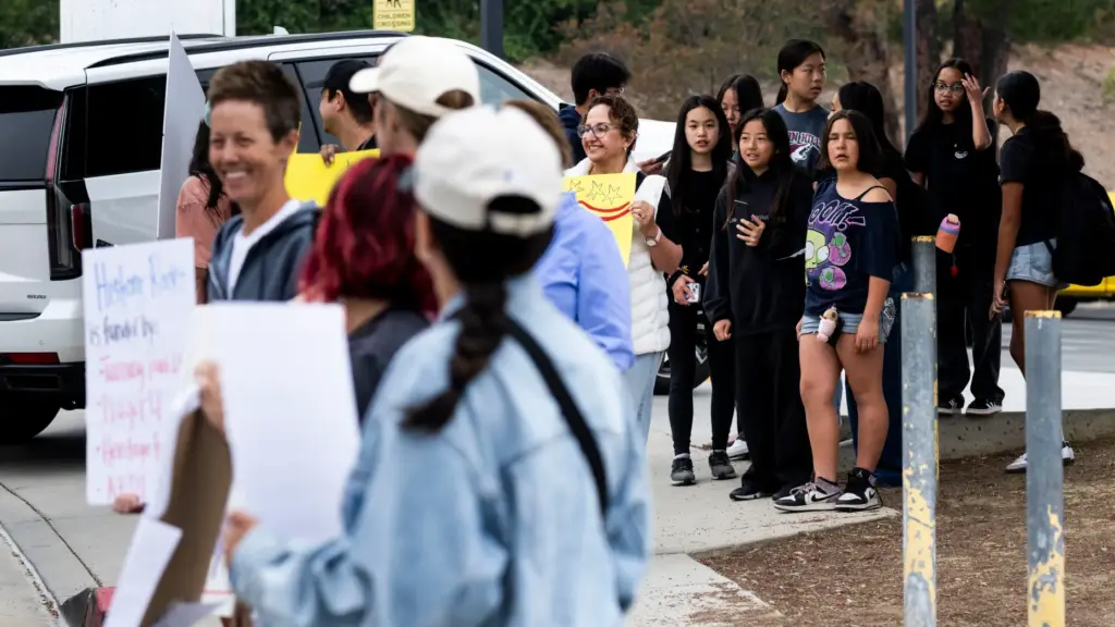 Students watch Friday, May 8, 2026, as protesters rally outside...