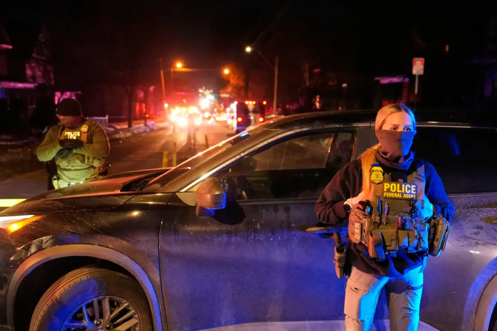 FILE – Federal immigration officers at the scene of a...
