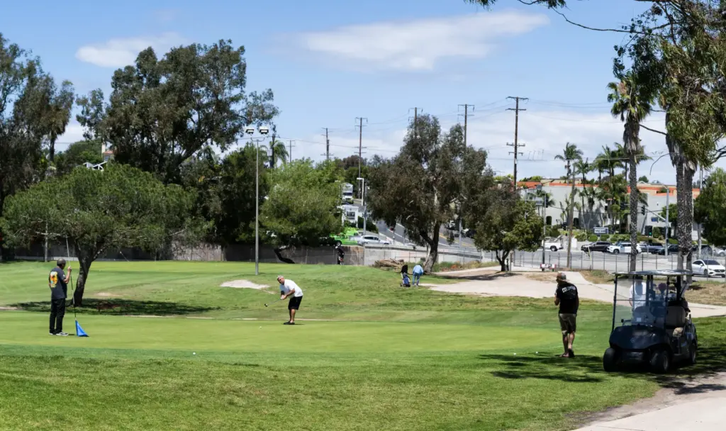 Golfers putt at Newport Beach Golf Course in Newport Beach...