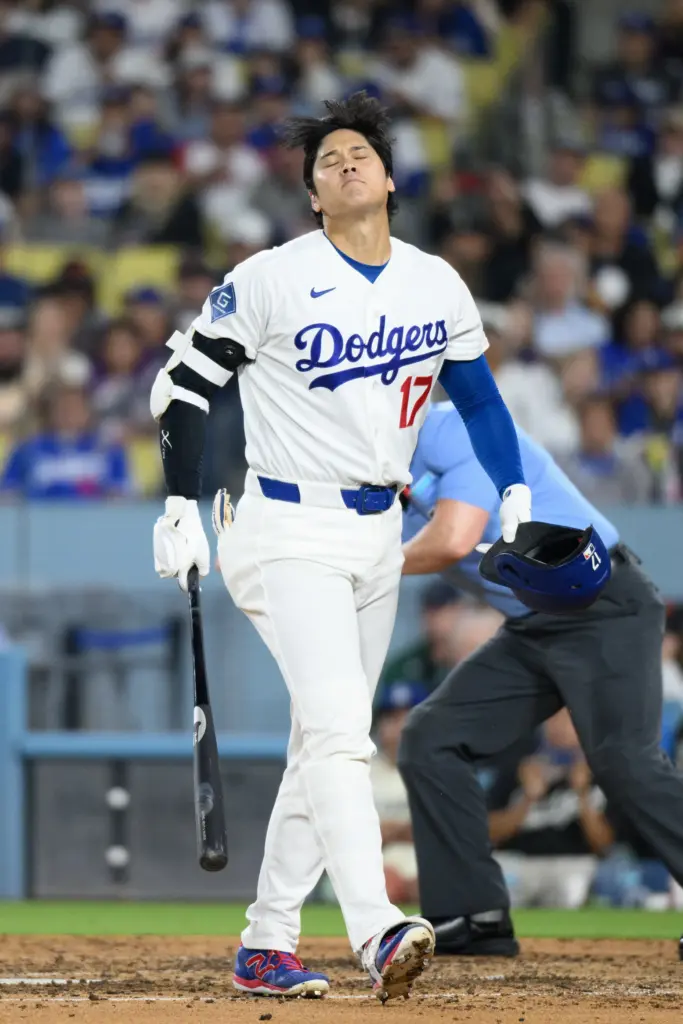 Dodgers star Shohei Ohtani walks back to the dugout after...